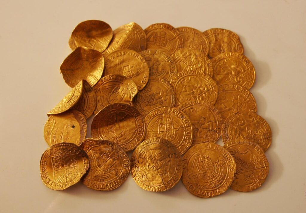 монета золотая. старинные монеты на ладони. старые золотые монеты. тихвин старинные монеты находки. рука с монетой.