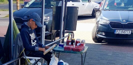 Niesamowity chłopak z Gniezna wzruszył serca internautów! Chłopiec z Gniezna sprzedaje maliny i przetwory mamy czytając książki